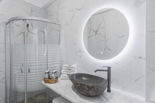 a bathroom with a sink and a mirror at Alpha & Omega in Karpathos Town