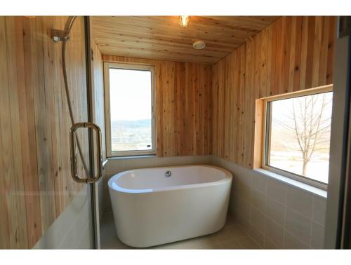 uma banheira na casa de banho com uma janela em N-vacation - Vacation STAY 46575v em Biei
