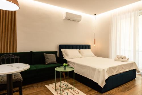 a bedroom with a bed and a green couch at Tranquil Studio in Tirana in Tirana