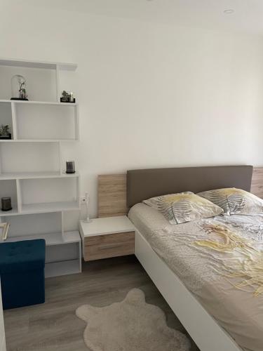 a bedroom with a bed with white shelves and a rug at Appartement neuf près de la mer in Nice