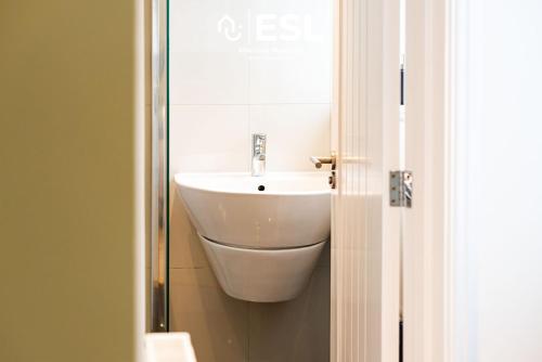 a bathroom with a white sink and a mirror at 2 Bedroom Terrace Cottage, Parking, 5 minutes drive to Royal Shrewsbury Hospital in Shrewsbury