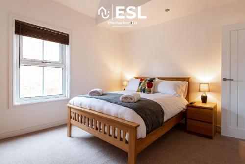 a bedroom with a large bed and a window at 2 Bedroom Terrace Cottage, Parking, 5 minutes drive to Royal Shrewsbury Hospital in Shrewsbury