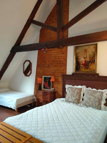- une chambre mansardée avec un lit et un banc dans l'établissement Château de Sainte Colombe sur Gand, à Sainte-Colombe-sur-Gand