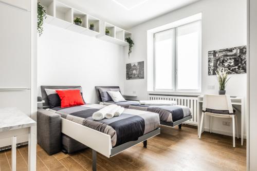 a bedroom with two beds and a desk and a window at [City Life House-RED] San Siro & Duomo in Milan