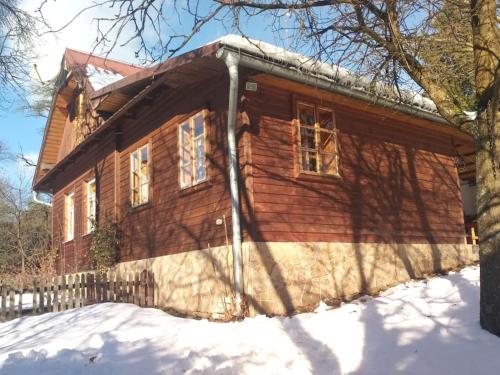 a log cabin with snow on the ground in front of it at Dřevěnice u Azzyho in Lačnov