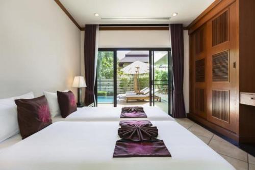 a hotel room with two beds and a balcony at Residence Lake Rawai in Phuket Town