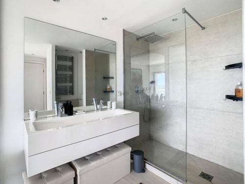 ein weißes Bad mit einem Waschbecken und einer Dusche in der Unterkunft Magnifique appartement vue mer in Vallauris