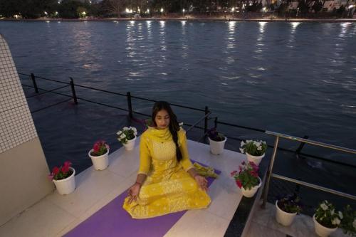 a girl in a yellow dress sitting on the deck of a boat at Perfectstayz Premium Ganga Heights at Harkipauri Road in Haridwār