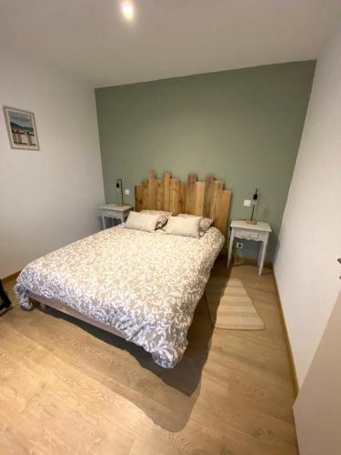 a bedroom with a bed with a wooden headboard at L'Escale Marine in Saint-Lunaire