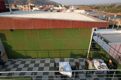 a view of a building with people sitting at a table at Perfectstayz Premium Ganga Heights at Harkipauri Road in Haridwār