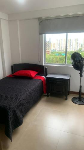 a bedroom with a black bed and a window at Apartamento amoblado nuevo in Pereira