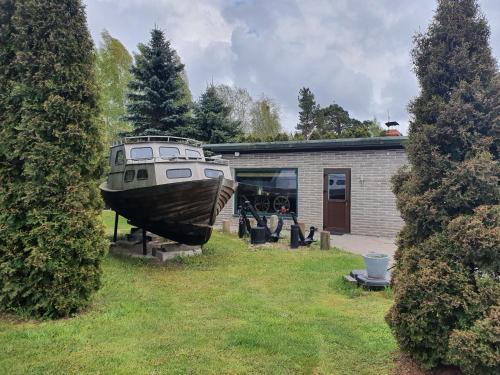 łódź wystawiona przed domem w obiekcie 100SaulesVikingi w mieście Grobiņa