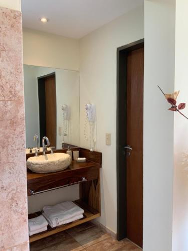 uma casa de banho com um lavatório e um espelho em LA TOSCANA casas y suites em Nono