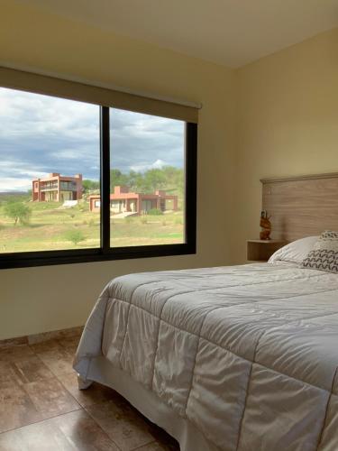 sypialnia z łóżkiem i dużym oknem w obiekcie LA TOSCANA casas y suites w mieście Nono