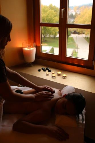 a woman getting a massage in front of a window at Convento Da Serta Hotel in Sertã