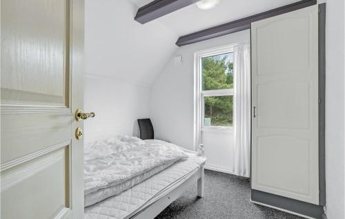 una camera bianca con un letto e una finestra di Stunning Home In Blvand With Kitchen a Blåvand