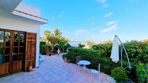 un patio con ombrellone, tavolo e sedie di Alba Chiara B&B a San Vito lo Capo