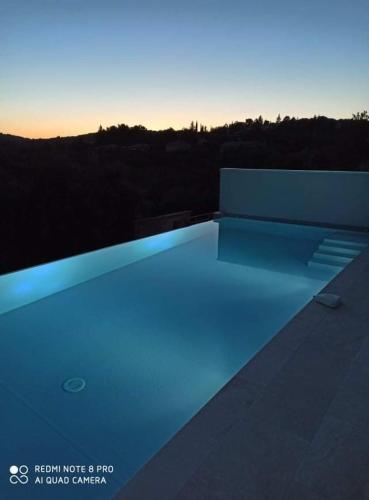 - une piscine avec éclairage bleu au-dessus d'un bâtiment dans l'établissement À mont nos hôtes, à Mollans-sur-Ouvèze