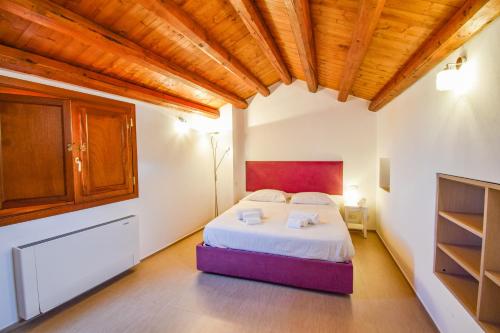 1 dormitorio con cama y techo de madera en La Rosa dei Venti, en Cefalú