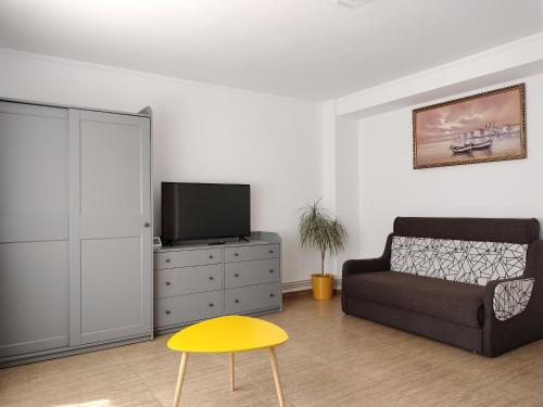- un salon avec un canapé et une télévision dans l'établissement Apartament Faleza Nord, à Constanţa