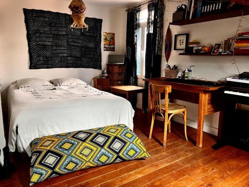 ein Schlafzimmer mit einem Bett, einem Schreibtisch und einem Klavier in der Unterkunft Maison de charme à Montreuil, à 10mn de Paris in Montreuil