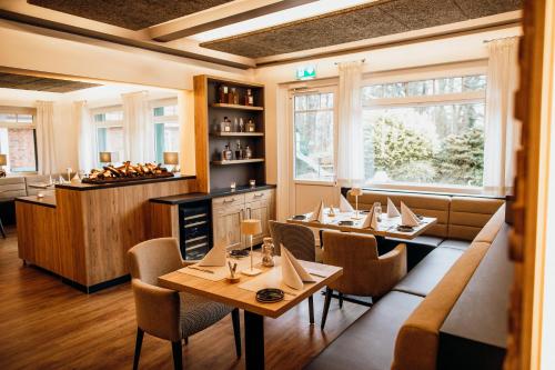 ノルドホルツにあるLandgasthof "Zum grünen Walde"のテーブルと椅子、カウンター付きのレストラン