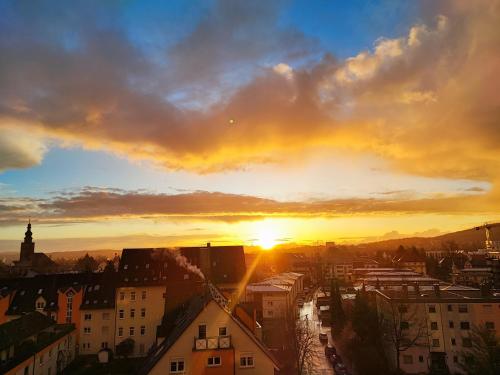 a sunset over a city with the sun setting at Wagners Panorama in Bayreuth