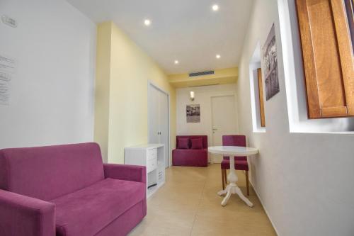 a living room with a purple couch and a table at La Rosa dei Venti in Cefalù