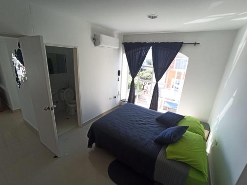 a bedroom with a bed and a large window at Studio In Novalito Neighborhood in Valledupar