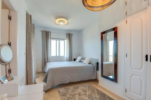 a bedroom with a bed and a mirror at Beachfront Townhouse Estepona in Estepona