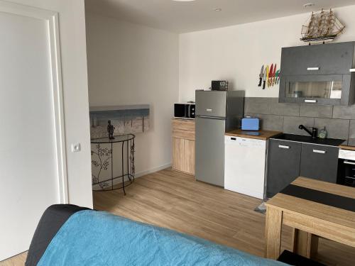 un salon avec une cuisine et une table dans l'établissement Hôtel L'Embarcadère, à La Barre-de-Monts