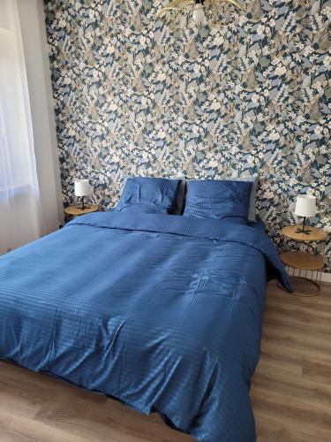 a bed with a blue comforter in a bedroom at Les oursins-appartement 3pièces, 4 couchages et parking gratuit in Metz
