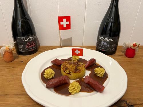 a plate of food with two bottles of wine at Hotel Fassbind Beausite in Beatenberg
