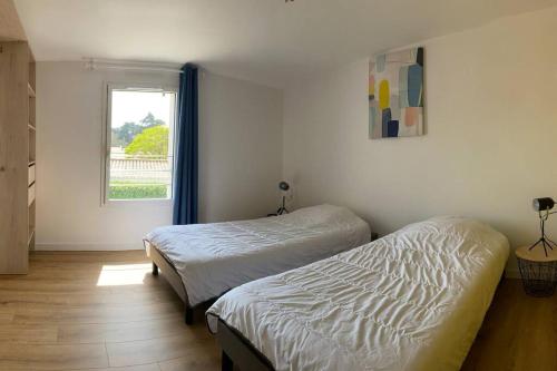 1 Schlafzimmer mit 2 Betten und einem Fenster in der Unterkunft Maison de 200 m2, récente à Noirmoutier en île in LʼHerbaudière