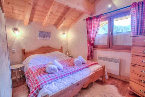 un dormitorio con una cama con dos animales de peluche en Anna - Chalet - BO Immobilier, en Châtel