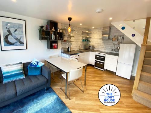 a kitchen and a living room with a couch and a table at Welcome to The Light House a tranquil city retreat. in Southampton