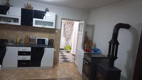 a kitchen with black and white cabinets and a stove at Apartmani ,,Bato,, in Sjenica