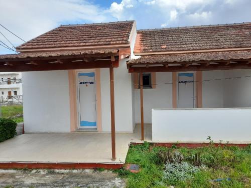 a small white house with a white wall in front at Sidari Studios in Sidari