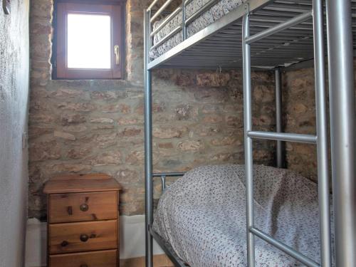 1 dormitorio con litera y tocador de madera en Casita Joya, en Perelló