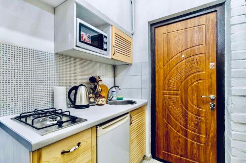 リヴィウにあるNice and stylish apartmentのキッチン(シンク付)、木製のドア