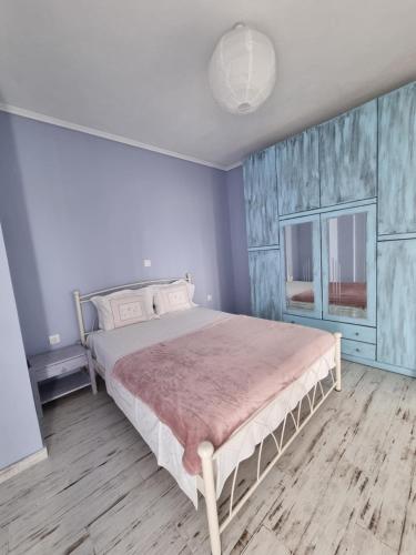 a bedroom with a bed and a wooden floor at Tararas apartments in Nea Michaniona