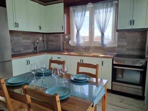 a kitchen with a table with plates and glasses on it at Tararas apartments in Néa Michanióna