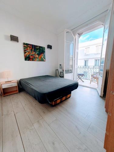 Cet appartement comprend une chambre dotée d'un lit et d'un balcon. dans l'établissement Climatisé,coeur de Juan-les-Pins, à Juan-les-Pins