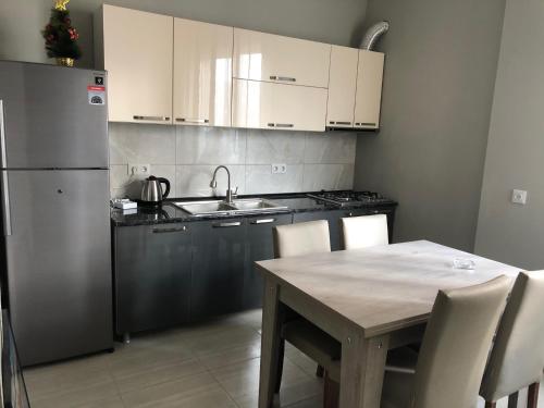 a kitchen with a table and a stainless steel refrigerator at Hotel Nikea in Kutaisi