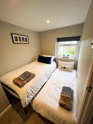 two beds in a small room with towels on them at Auctioneers Cottage in Louth