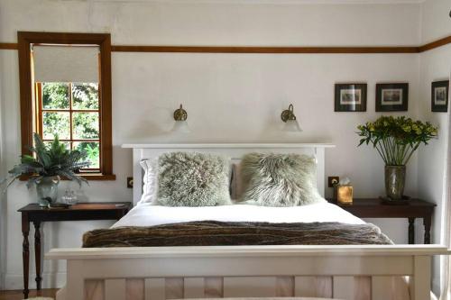 ein weißes Bett mit Kissen auf dem Zimmer in der Unterkunft Forth River Cottage in Forth