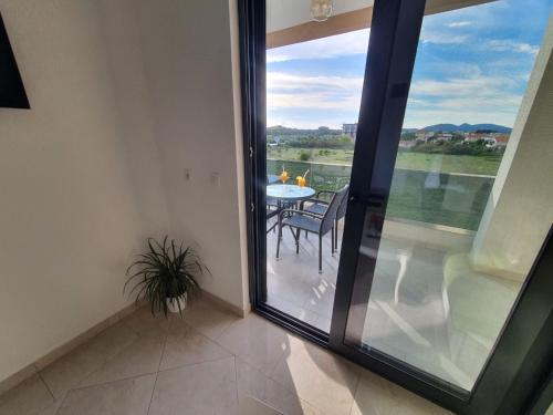 a balcony with a table and a glass door at Apartments Alsa in Ulcinj