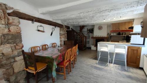 une cuisine et une salle à manger avec une table et des chaises dans l'établissement Gîte LA BOUSCARLE, à Moissac-Bellevue