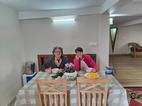 deux personnes assises à une table avec de la nourriture dans l'établissement Gurung homestay, à Darjeeling