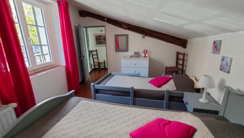 - une chambre avec 2 lits et des oreillers roses dans l'établissement Gîte LA BOUSCARLE, à Moissac-Bellevue